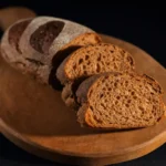 Freshly baked homemade sandwich bread loaf with golden crust and soft slices on a wooden cutting board