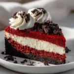 Red Velvet Cheesecake with Oreo Crust slice topped with whipped cream