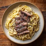 Steak carbonara pasta with sliced steak and Parmesan