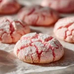 Valentine’s Day Crinkle Cookies , soft pink cookies rolled in powdered sugar on a baking tray