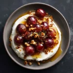 Whipped feta dip topped with roasted grapes, walnuts, and hot honey drizzle